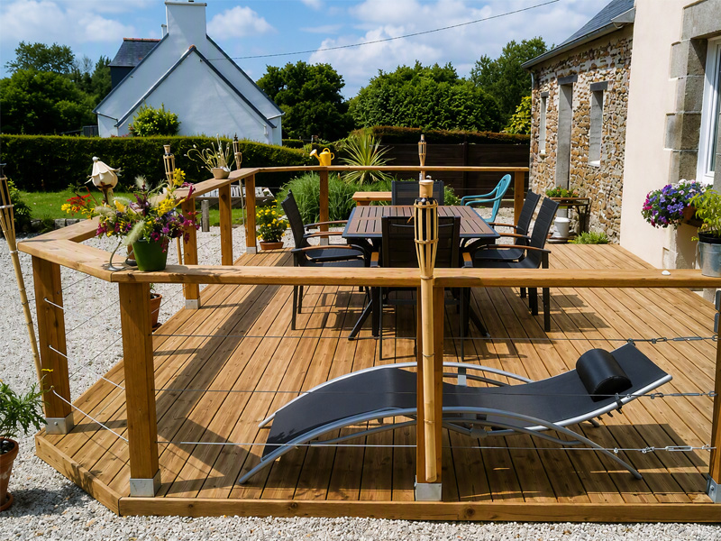 Terrasse en bois avec garde-corps, mobilier de jardin et espace détente aménagés par Proseco Paysages